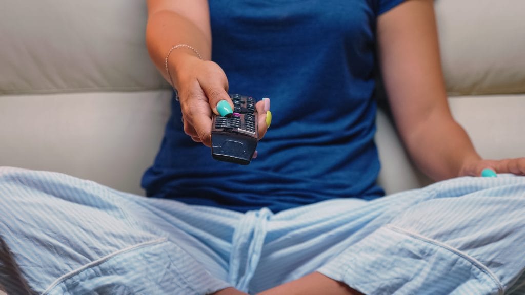 Woman changing channel on tv