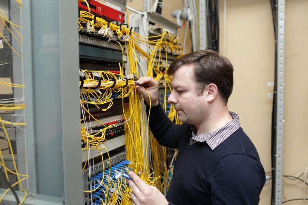 man installing fibre cables