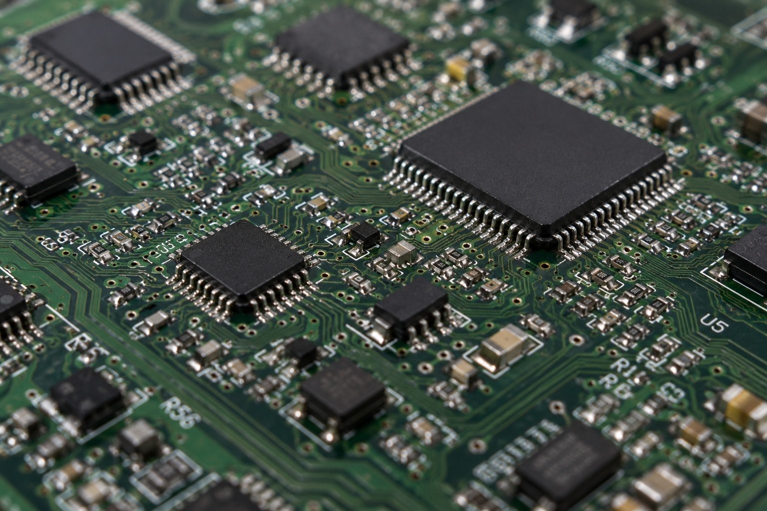 Close-up of a PCB with fine-pitch integrated circuits and surface-mounted components for high-density electronics.